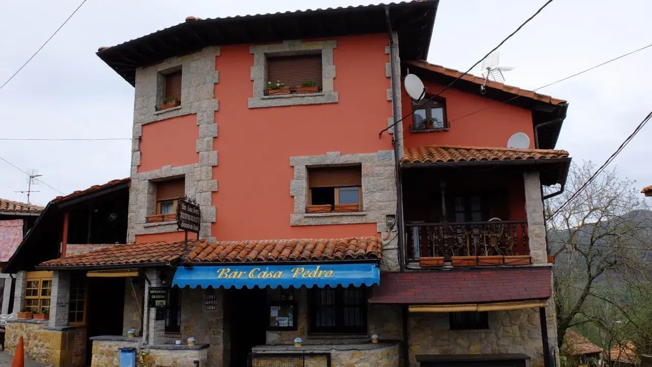 Casa Pedro, restaurante y alojamiento rural, con su fachada naranja y detalles de piedra, invita a disfrutar de la gastronomía y la tranquilidad del campo.