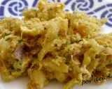 Un plato de alheira que es una deliciosa mezcla desmenuzada de carne, patatas y hierbas, servido en un plato blanco con un patrón azul.