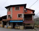 Casa Pedro, restaurante y alojamiento rural, con su fachada naranja y detalles de piedra, invita a disfrutar de la gastronomía y la tranquilidad del campo.