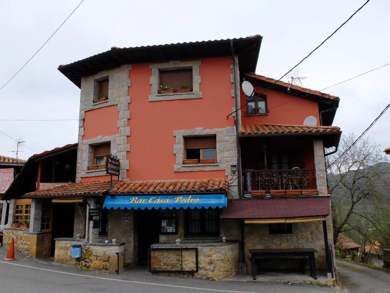 Casa Pedro, restaurante y alojamiento rural, con su fachada naranja y detalles de piedra, invita a disfrutar de la gastronomía y la tranquilidad del campo.
