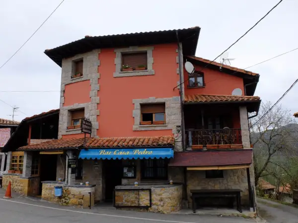 Casa Pedro, restaurante y alojamiento rural, con su fachada naranja y detalles de piedra, invita a disfrutar de la gastronomía y la tranquilidad del campo.