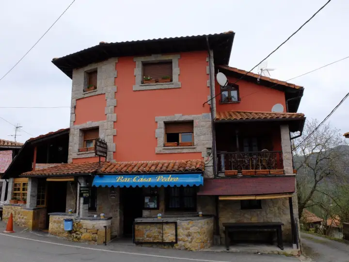 Casa Pedro, restaurante y alojamiento rural, con su fachada naranja y detalles de piedra, invita a disfrutar de la gastronomía y la tranquilidad del campo.