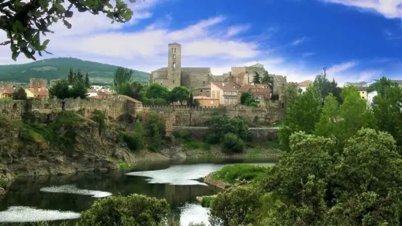 Pueblos de la sierra de Madrid con un río y un castillo medieval.